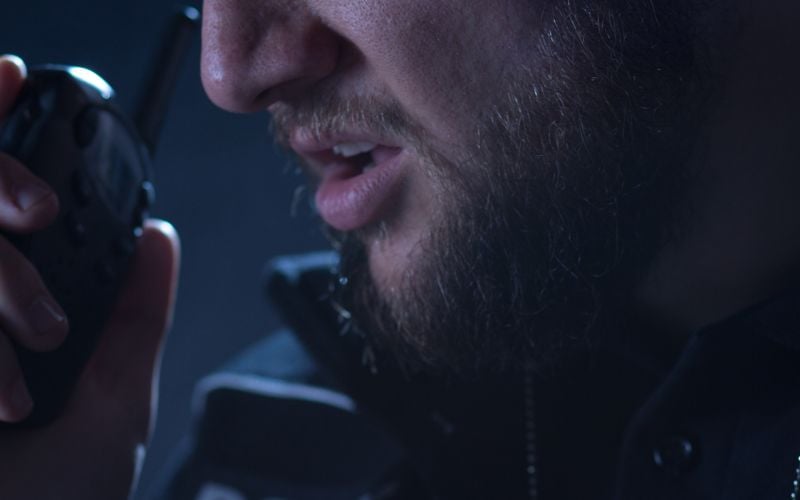 Up close of a man talking into a handheld radio