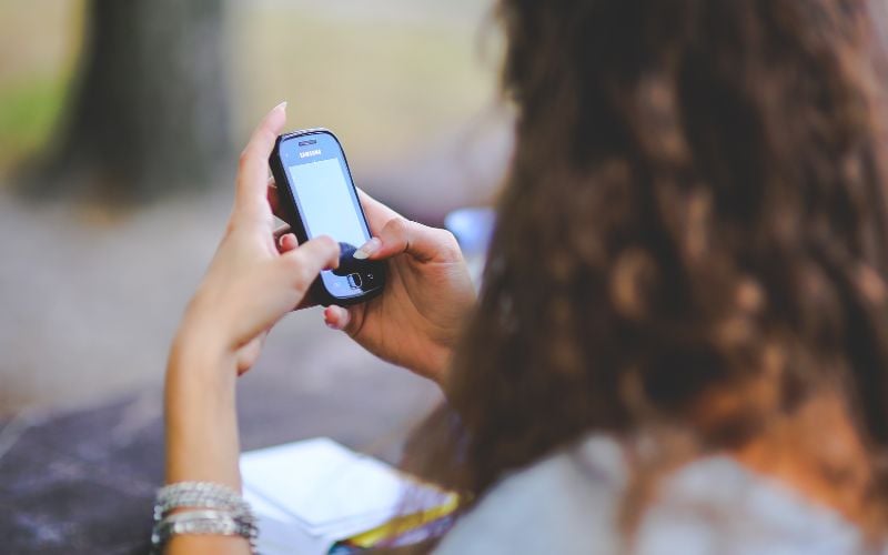 Woman from behind looking at a cell phone screen